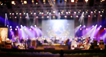 Blurred background : Bokeh lighting in concert with audience ,Music showbiz concept, music performance concert with bokeh spotlight. entertainment concert lighting on stage, blurred disco party.