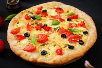 Pizza with tomato, mozzarella, basil and olives.