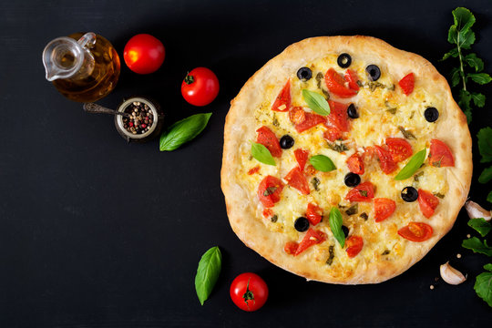 Pizza with tomato, mozzarella, basil and olives. Top view