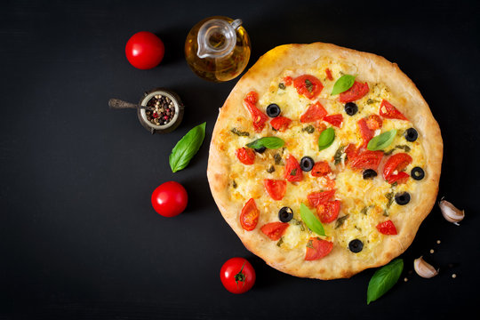 Pizza with tomato, mozzarella, basil and olives. Top view
