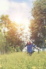 Fototapeta premium Attractive young woman standing in a field of yellow flowers, ha