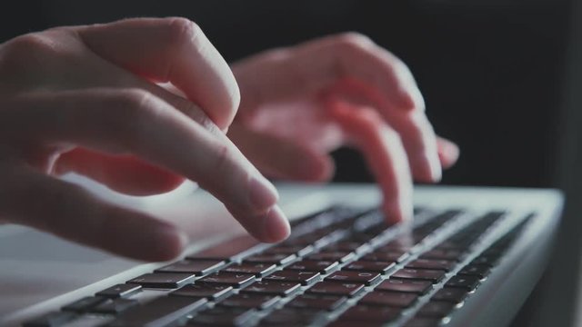 Extra close up of quckly typing work on computer. Typing text on a laptop computer keyboard. Black keyboard key. Networking. Typing message or email on laptop, searching in Internet