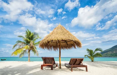 Fotobehang Zanzibar Vakantie in tropische landen. Strandstoelen, parasol en palmen op het strand.