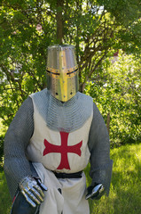 A person dresses up historically to mimic a knights templar in full armour