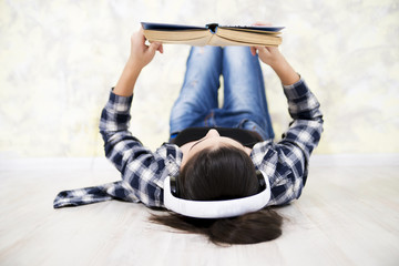 teen girl in headset reading a book