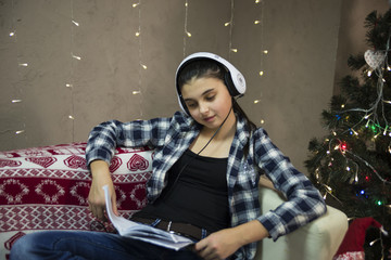 girl on sofa with headset near xmas tree