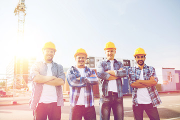 group of smiling builders in hardhats outdoors