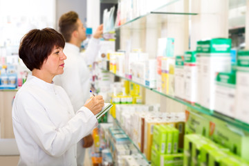 Pharmacist and pharmacy technician posing in drugstore