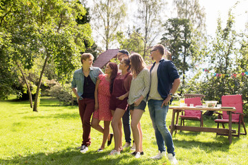 happy teenage friends talking at summer garden