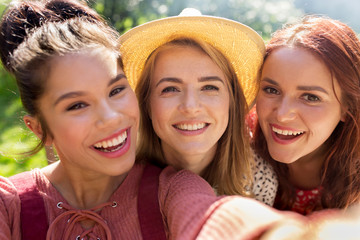 Obraz premium happy women or friends taking selfie at summer