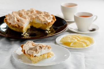 piece of lemon cake with a cups of tea