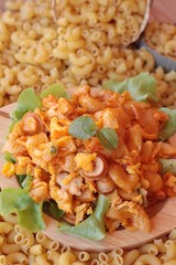 Fried macaroni with sausage and tomato sauce.