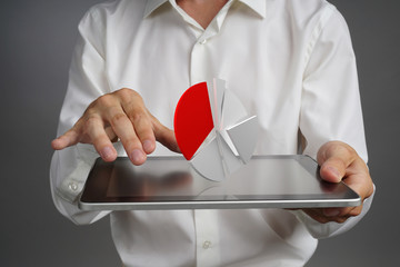 Man in white shirt working with pie chart on a tablet computer, application for budget planning or...