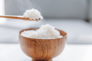 The wooden bowl is filled with rice.