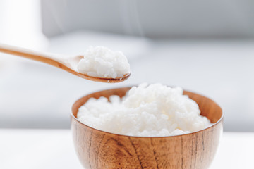 The wooden bowl is filled with rice.