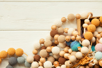 Knitted beads necklace on white wooden backroung