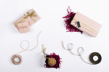 Gifts in boxes with ribbons and Christmas ball on a white table