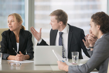 Furious boss scolding young frustrated interns with bad work results. Ineffective office workers...
