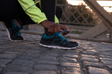 African american woman runner tightening shoe lace