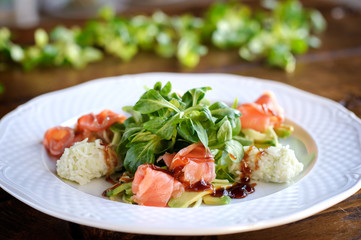 finest dining salad with smoked salmon, rice, herbs and avocado in white plate