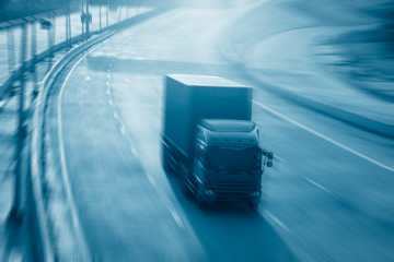 Obraz na płótnie Canvas Motion blurred trucks on highway. Transportation industry metaphor