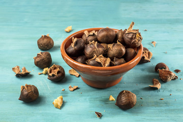Roasted chestnuts in earthenware bowl on turquoise