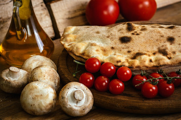Сalzone pizza on wood table with ingredients