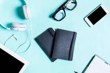 Working place with tablet, smartphone and glasses on a turquoise background