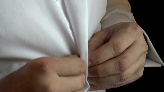 Man buttoning shirt closeup. Dressed man. Dressing up men's. Men hands. White shirt for the image of the gentleman.