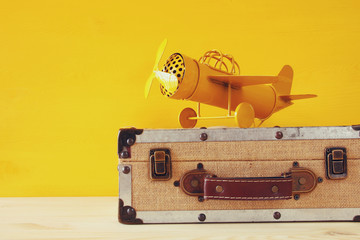 Photo of vintage yellow toy plane and old suitcase