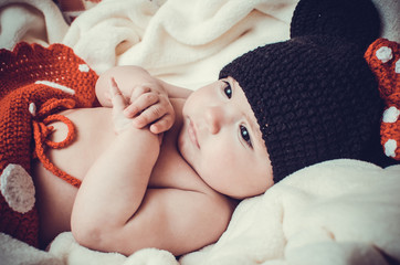 Little cute girl in black knitted hat looks at the world with th