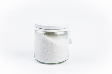 food or lifestyle, glass jar with salt or bath salt isolated in white background