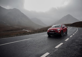 Car moving on road with mountains in background