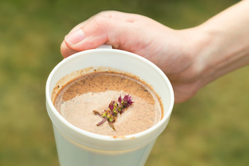 Hot drinks with a mixture of cocoa, chocolate and malt in woman hand.