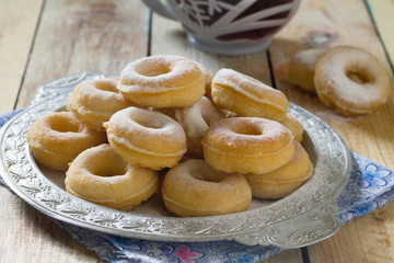 Donuts with powdered sugar on a wooden background. Hanukkah cele