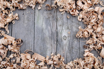 Wood shavings on weathered wooden background with space for text