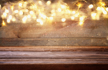 empty table in front of Christmas warm gold garland lights