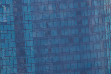 Windows of modern office building - architectural background. Toned in the blue color