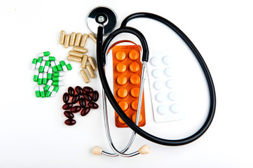 Stethoscope and medicine on white background