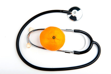 Stethoscope and Mandarin on white background