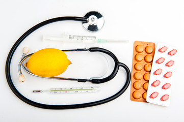 Stethoscope and medicine on white background