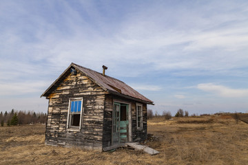 rustic old cabin in a large field