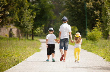 Fototapeta premium Young happy family walking in summer park