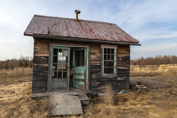 neglected cabin in a farmer field - Powered by Adobe