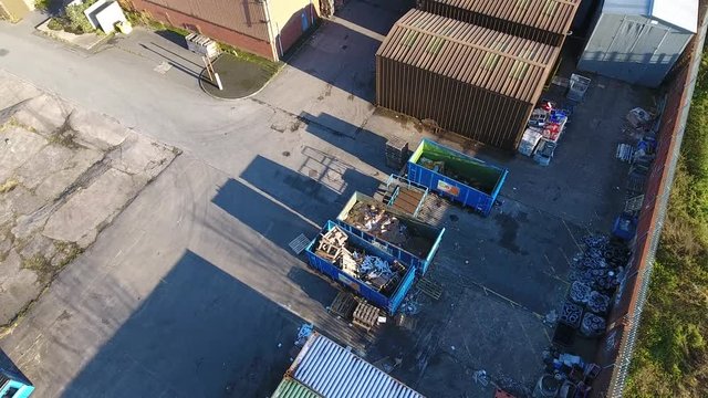 Orbiting aerial view of factory refuse skips.