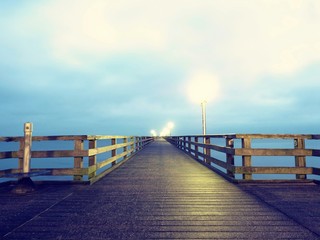 Naklejka premium Autumn dark mist on wooden pier above sea. Depression, dark atmosphere.