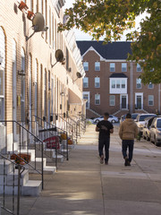 Two latino men walking on sidewalk
