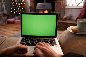 Man Using Laptop In Room Decorated For Christmas