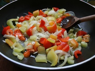 Peppers and onions in a pan close up