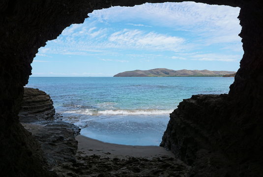 Exit of a tunnel in the rock on the sea shore connecting beaches of La Roche Percee to Turtle Bay, Bourail, Grande Terre, New Caledonia, south Pacific
